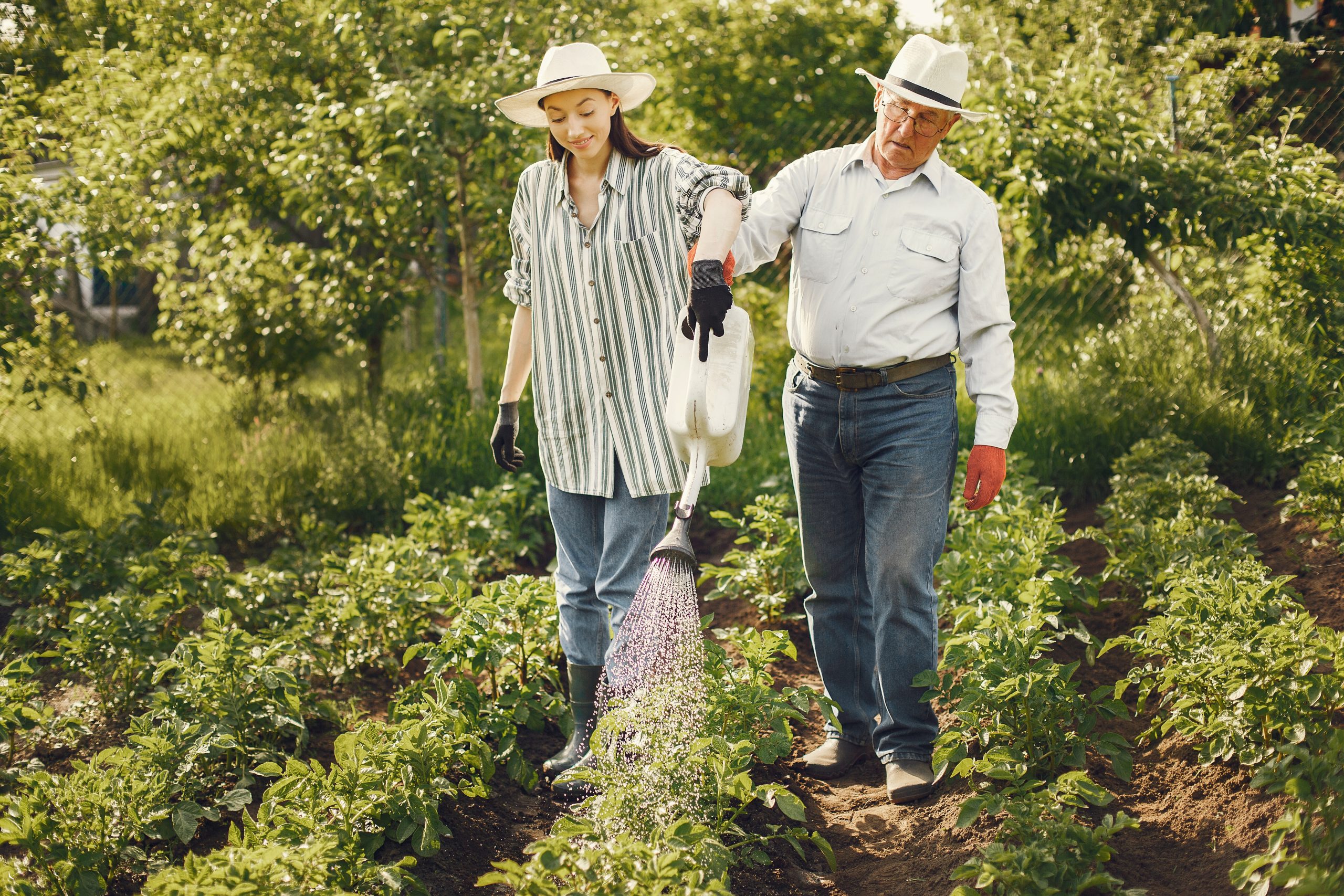 portrait senior man hat gardening with granddaugher scaled